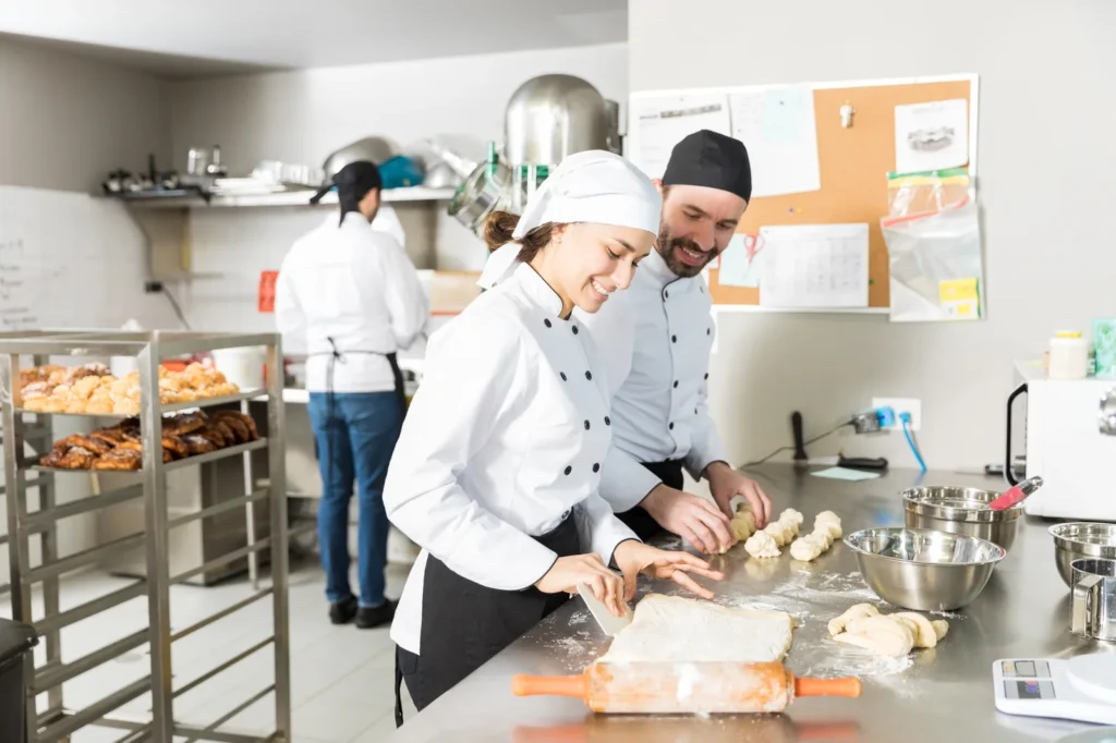 Bakers preparing dough while learning bakery course fees value