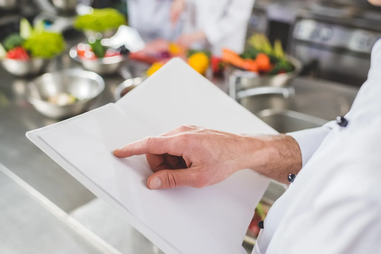 HACCP vs FSSAI: chef reviewing kitchen records in a commercial kitchen