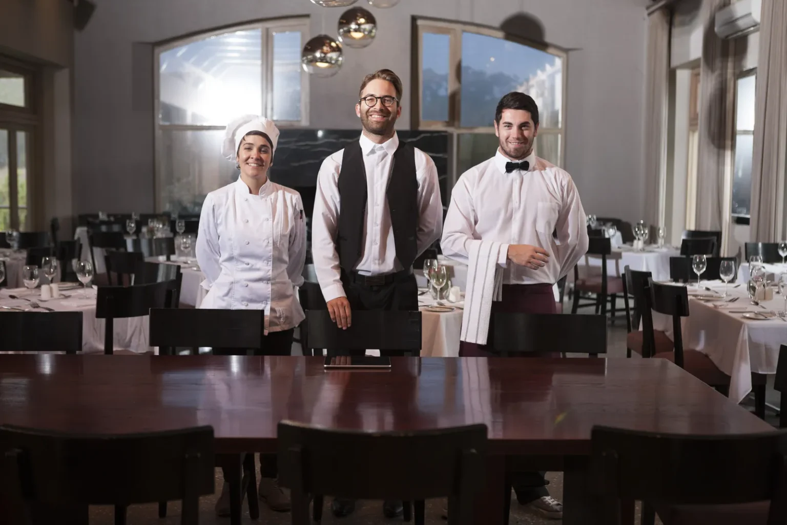 Restaurant team lined up in the dining room ready for service, representing a restaurant management course